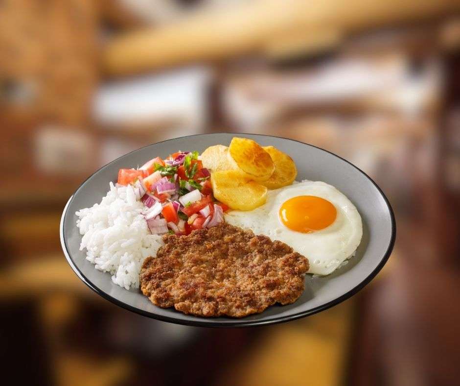 Bolivian Silpancho with fried egg, rice, potatoes, salad, and peanut soup served in a traditional restaurant setting